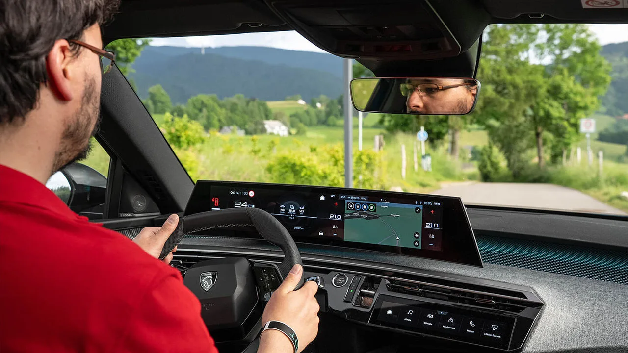 Aufnahme des Fahrers des Peugeot E-3008 im Innenraum von der Rückbank aus