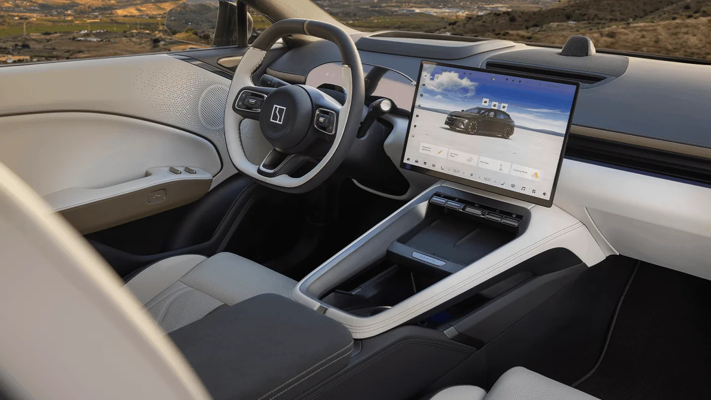 Innenraum des ZEEKR 7 GT mit hellem Cockpit, Lenkrad und großem zentralem Touchscreen.