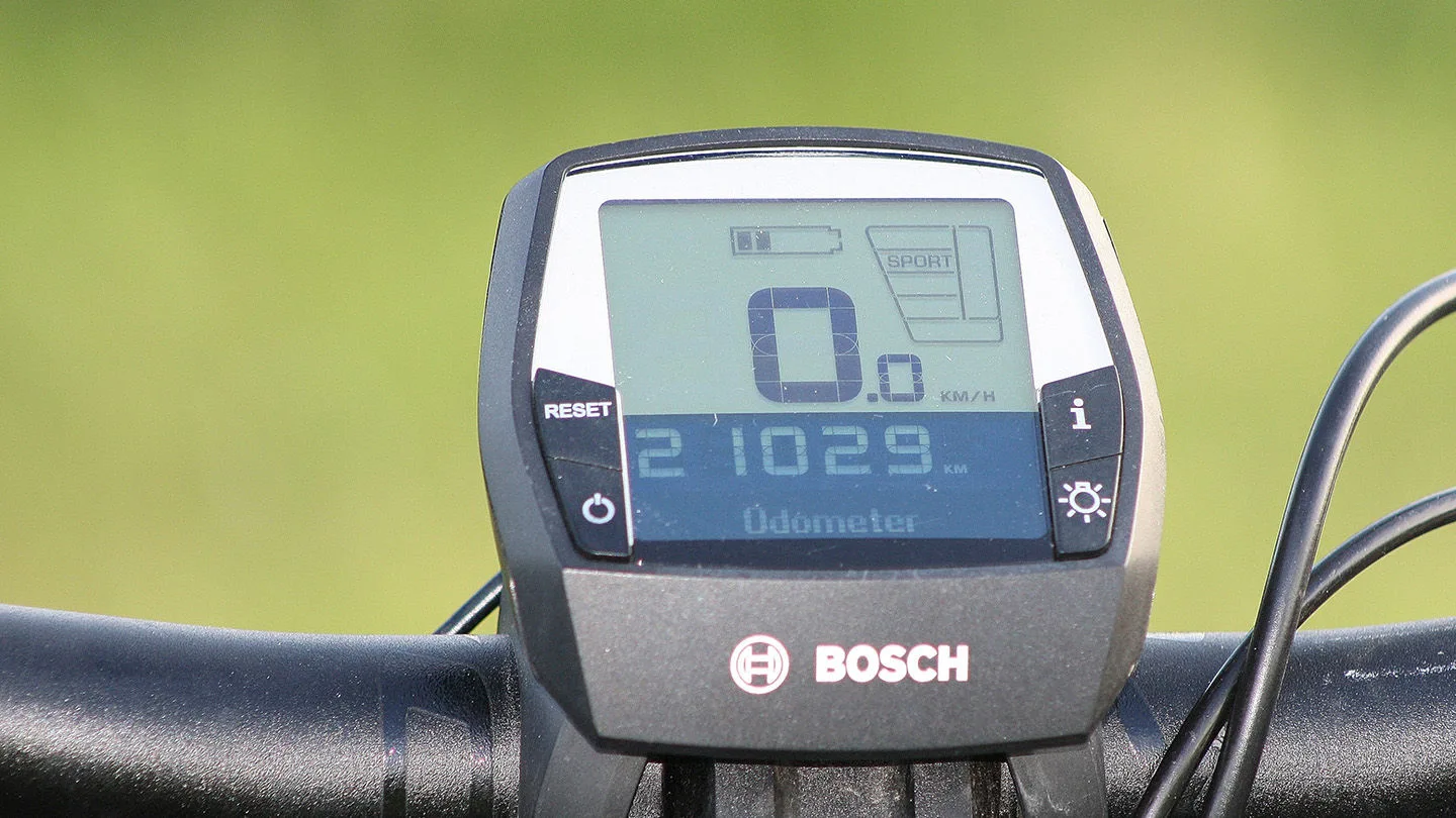 Nahaufnahme eines E-Bike-Displays am Fahrradlenker mit Anzeige von Geschwindigkeit, Akkustand, Fahrmodus und Kilometerstand