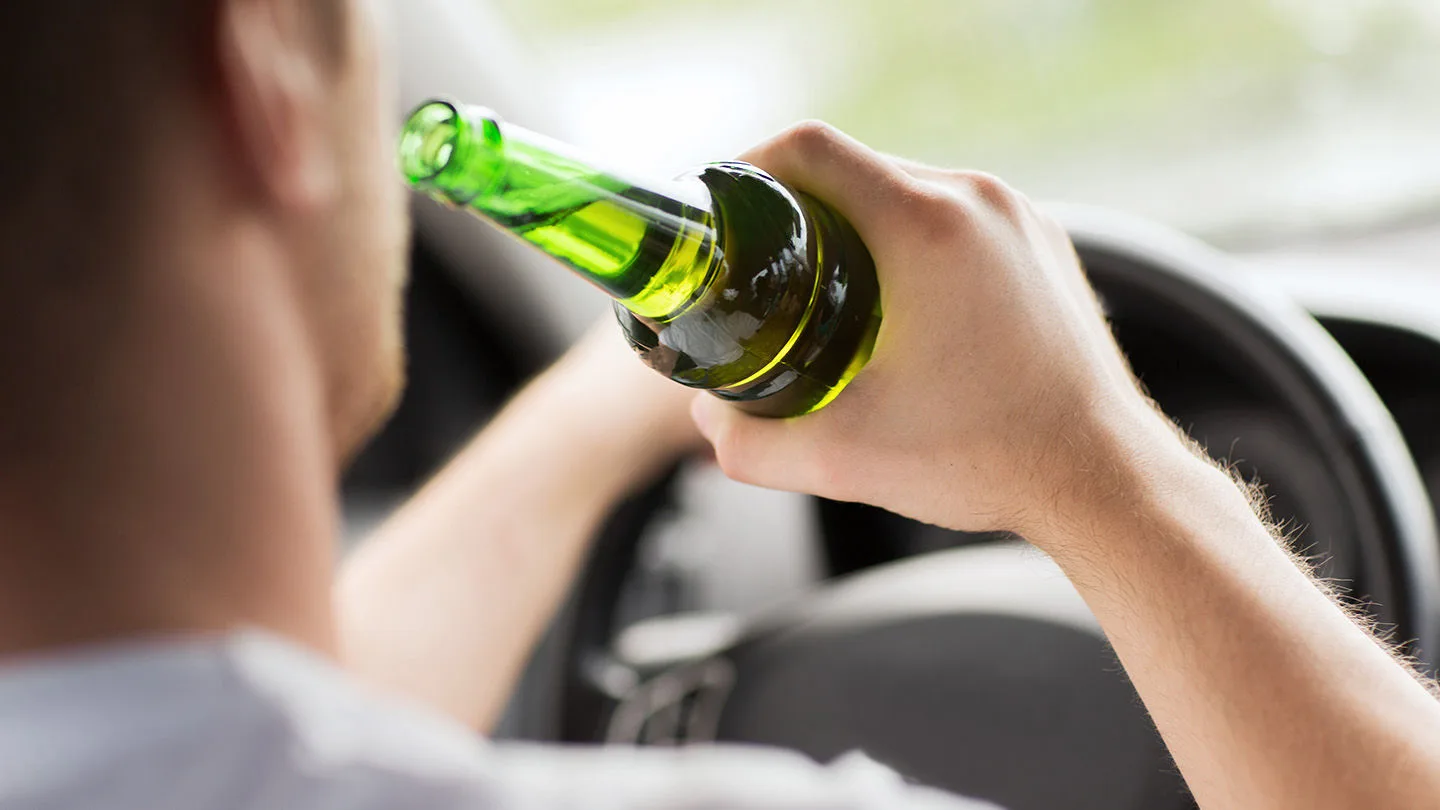 Fahrer trinkt Alkohol während der Fahrt