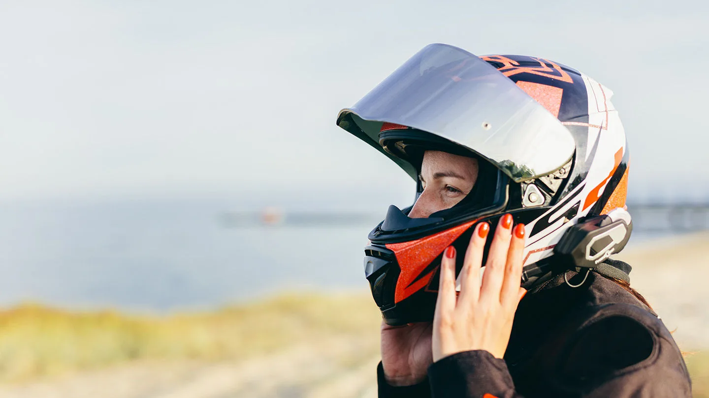 Eine Frau, die einen Integralhelm aufsetzt