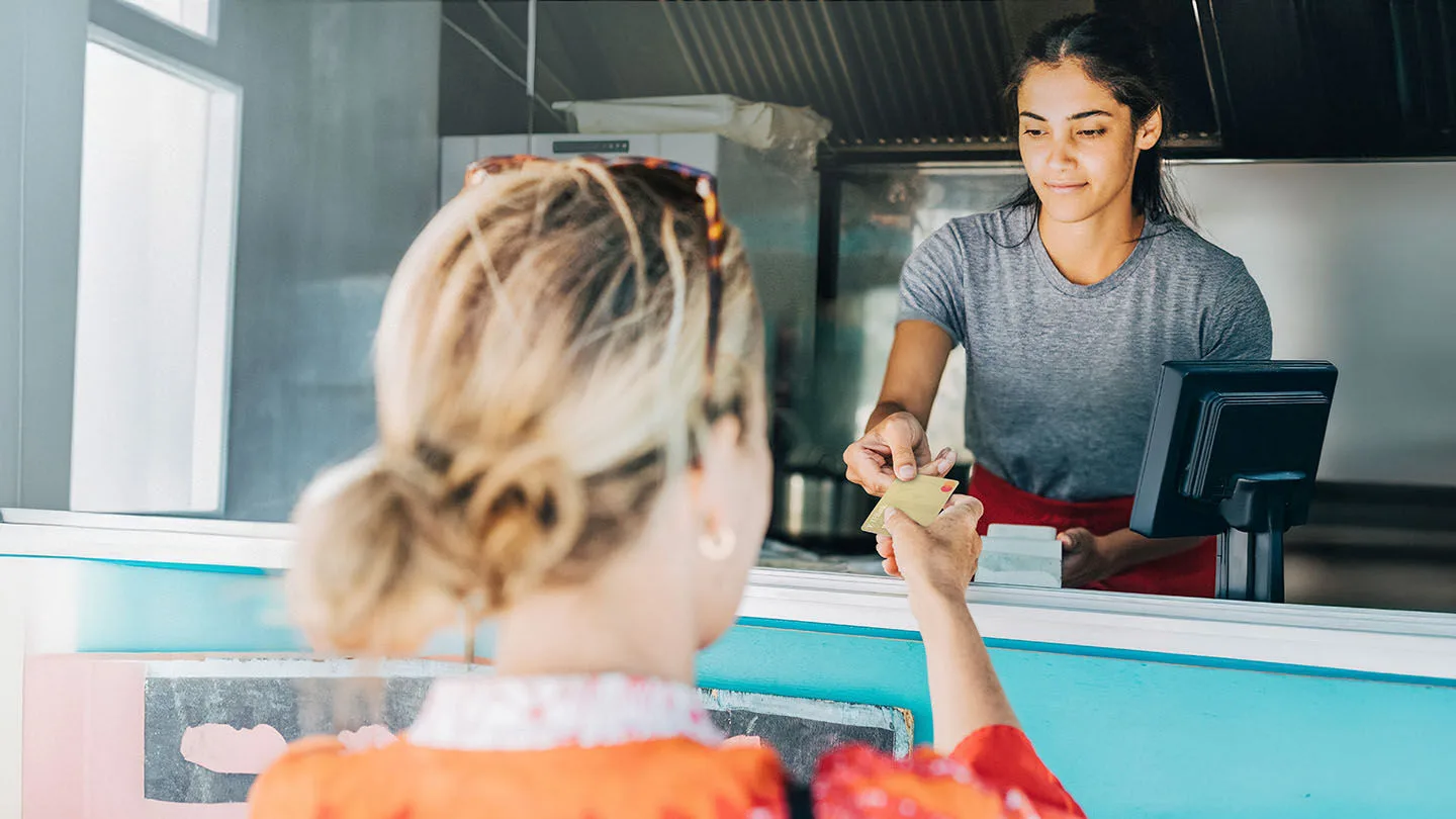 Frau zahlt ihren Einkauf mit ihrer ACE-Kreditkarte.