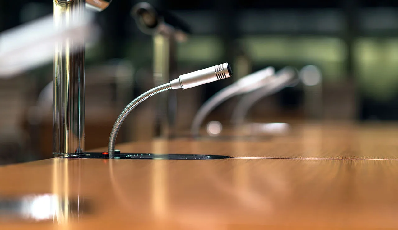 Ein Tisch mit einem Mikrofon für eine Pressekonferenz