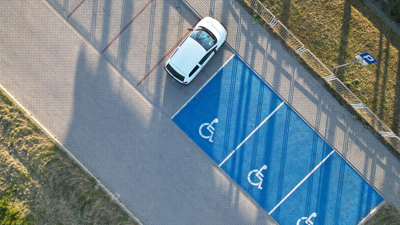 Luftaufnahme von einem Parkplatz mit Behindertenparkplätzen in blau