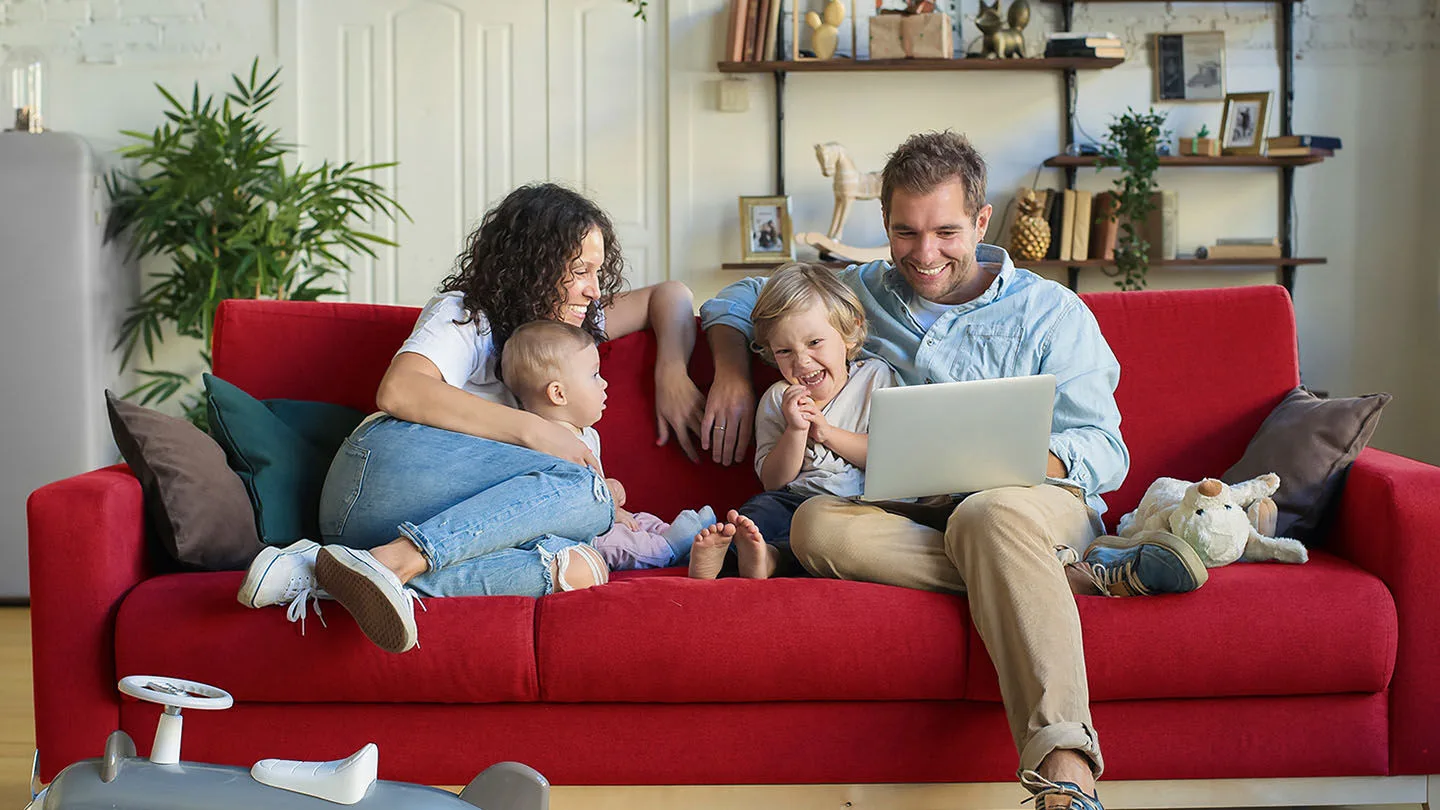 Ein Mann und eine Frau kuscheln auf dem Sofa und freuen sich über die Vorteile beim ACE.