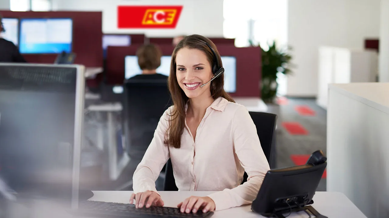 Eine Frau mit Headset sitzt im ACE Infoservice Callcenter