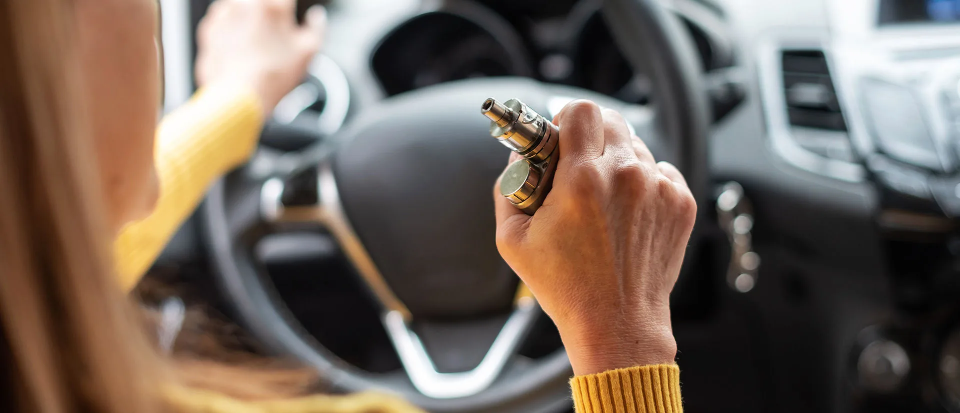 Frau raucht E-Zigarette im Auto