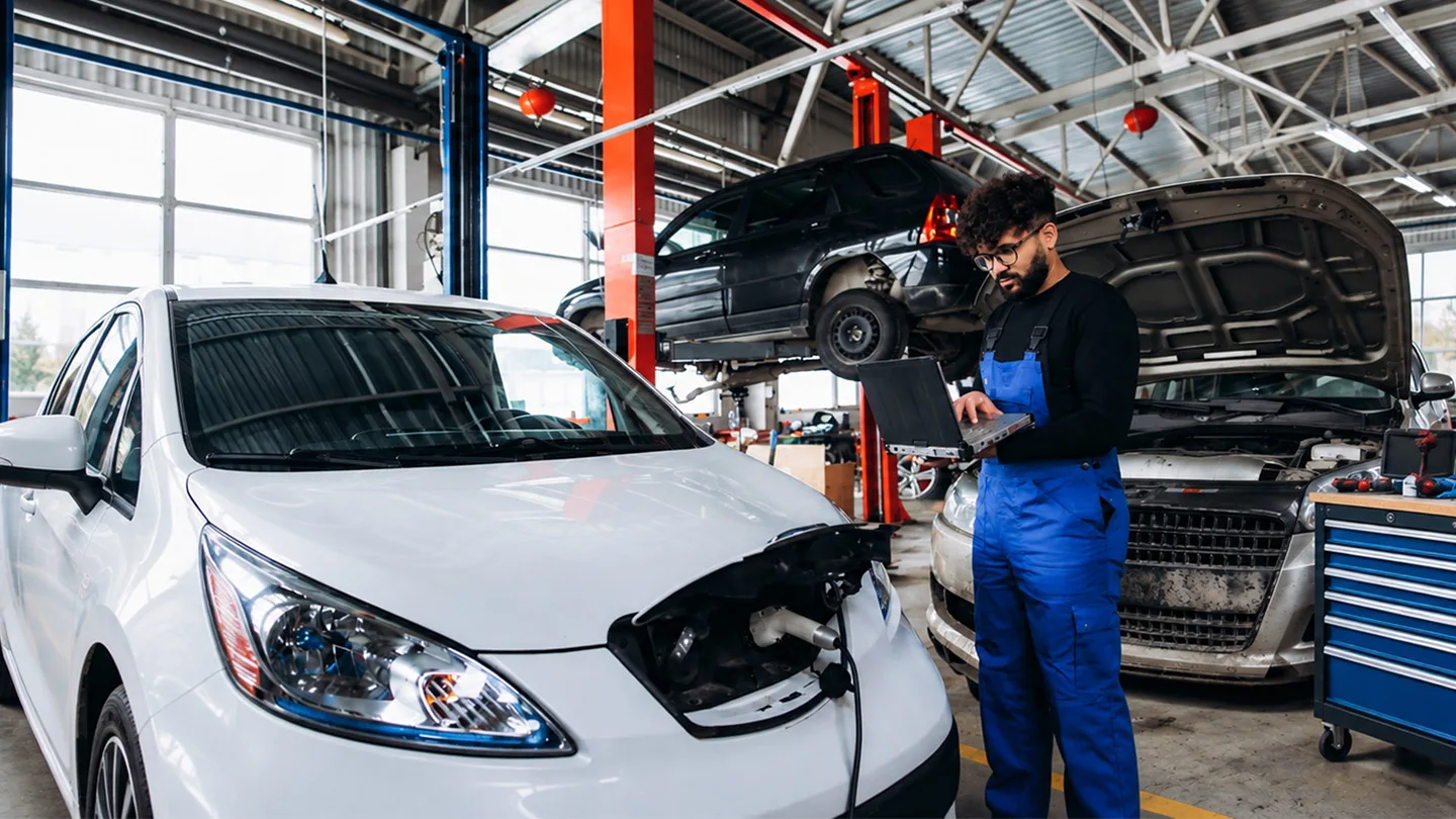 Mann bei der Reparatur eines E-Autos