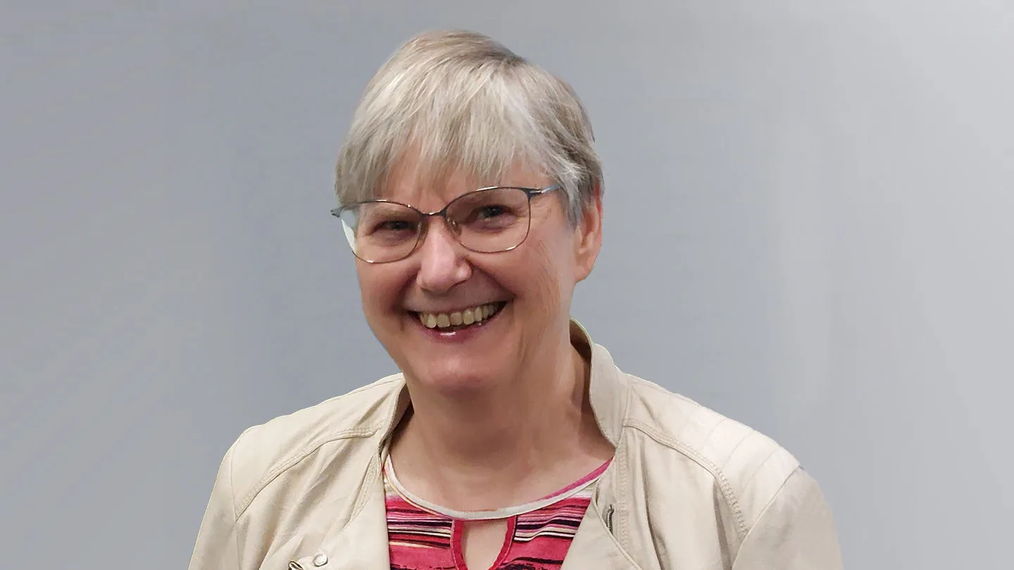 Frau mit Brille vor grauem Hintergrund