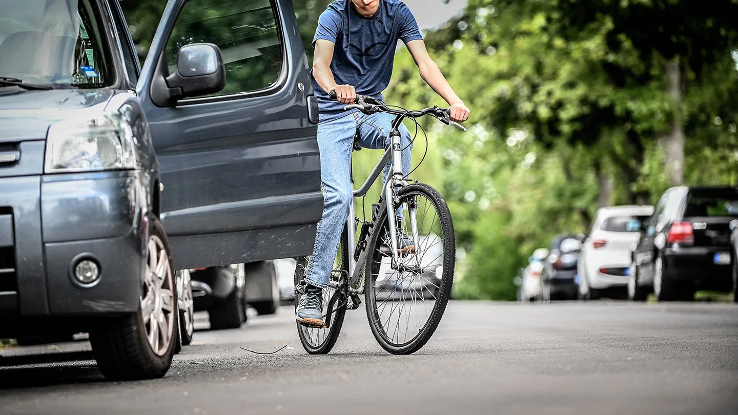Autofahrer öffent ohne zu schauen die Türe. Dooringunfälle sind gefährllich. 