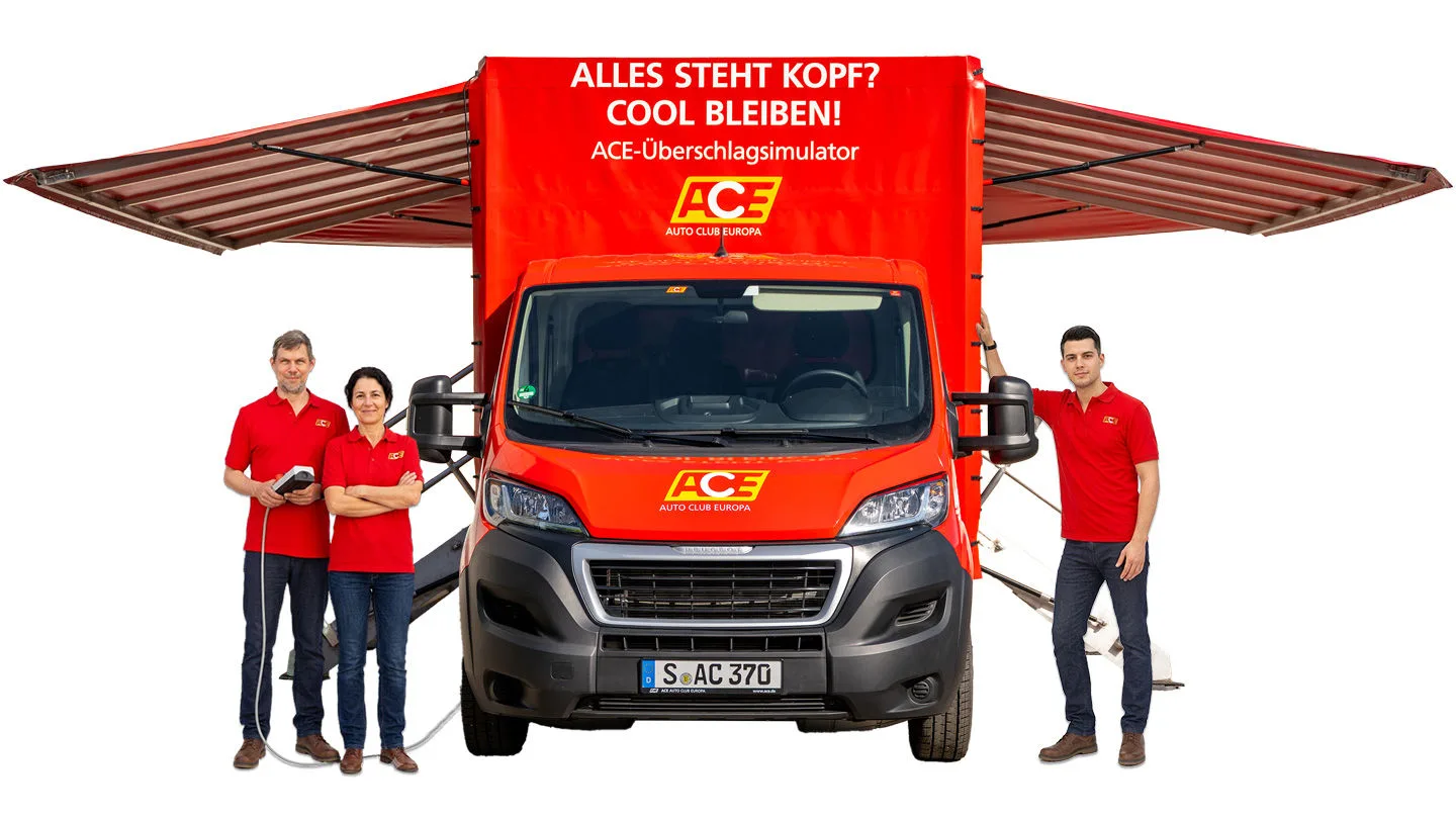 Zwei Moderatoren und eine Moderatorin des ACE stehen neben dem aufgestellten ACE-Überschlagsimulator.