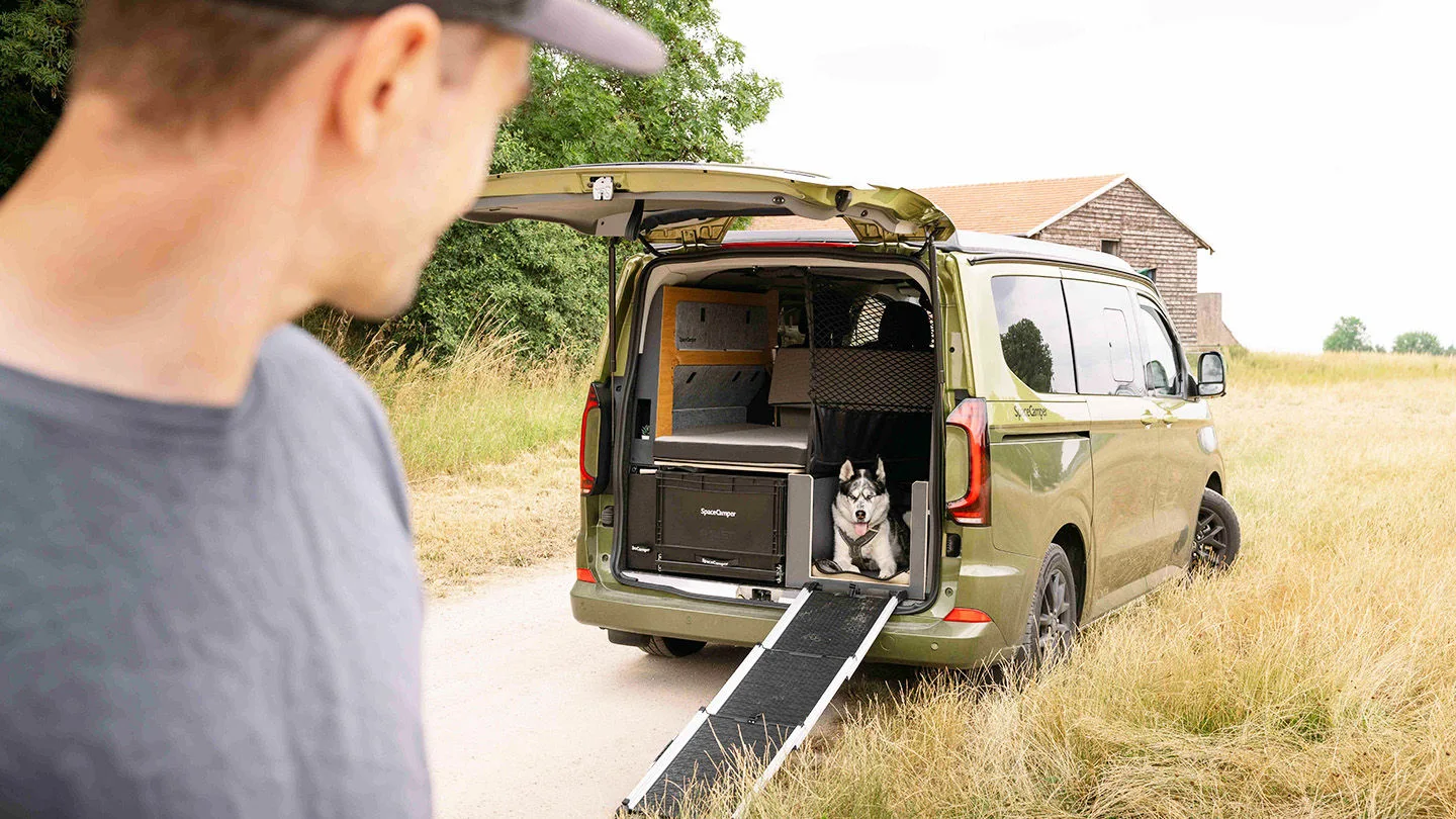 Space Camper mit offenem Kofferraum aus dem ein Hund herausschaut