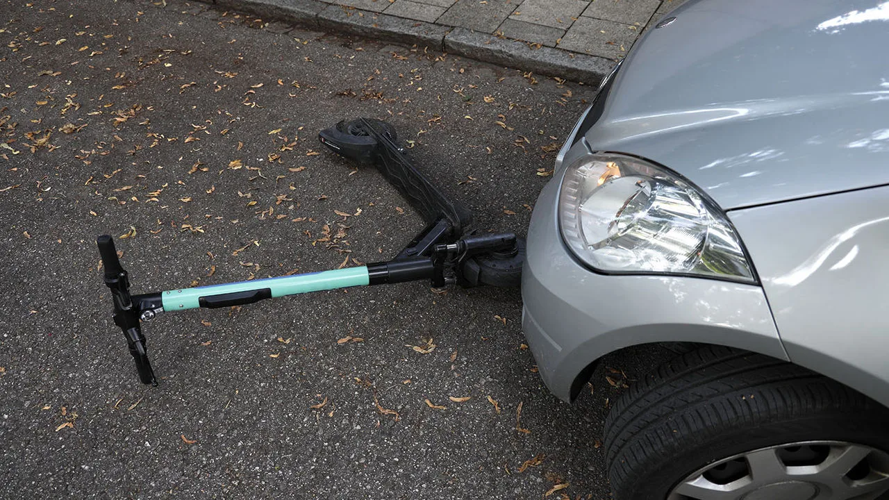 Ein E-Scooter liegt vor einem Auto, es kam zur Kollision 