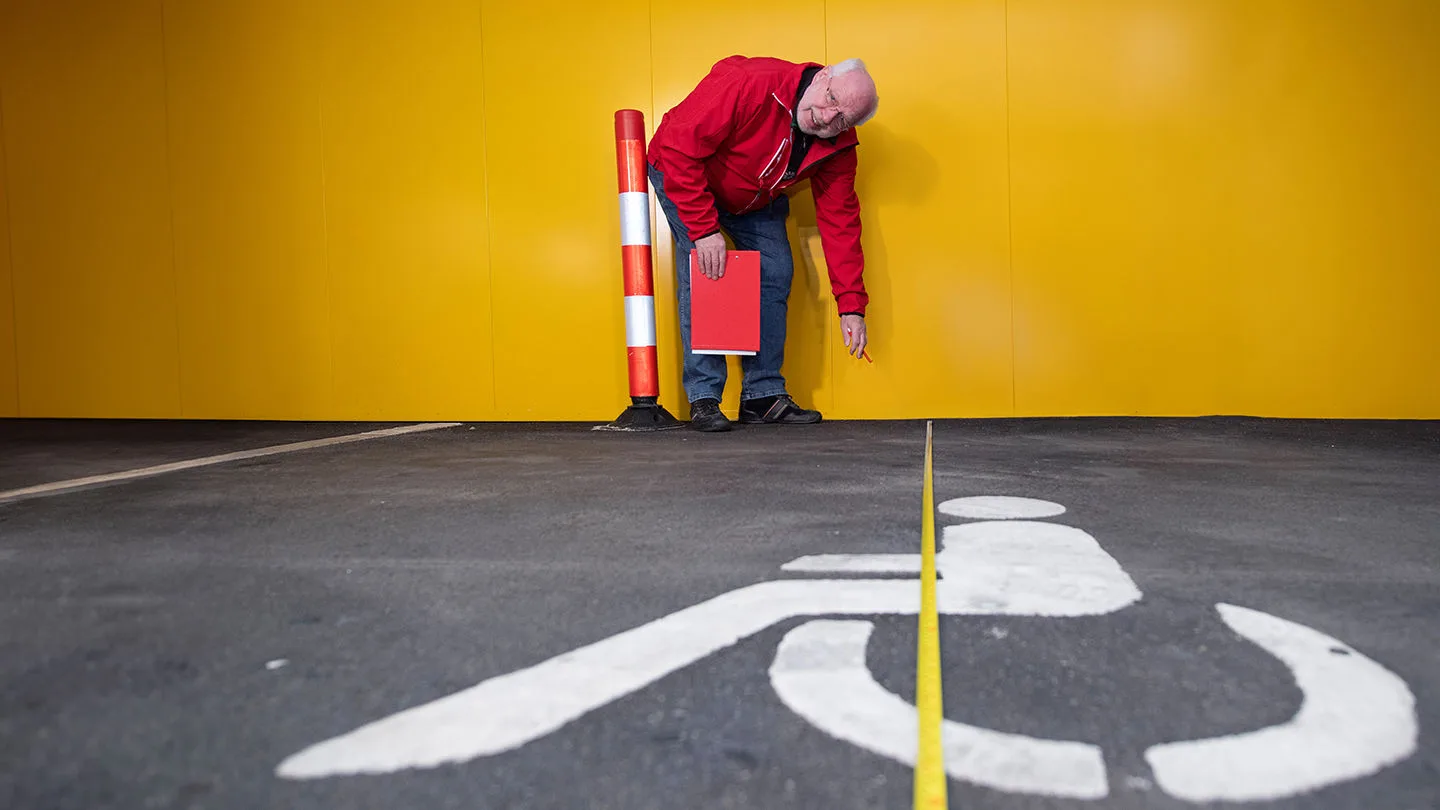 Mann bei der Parkplatzbemessung