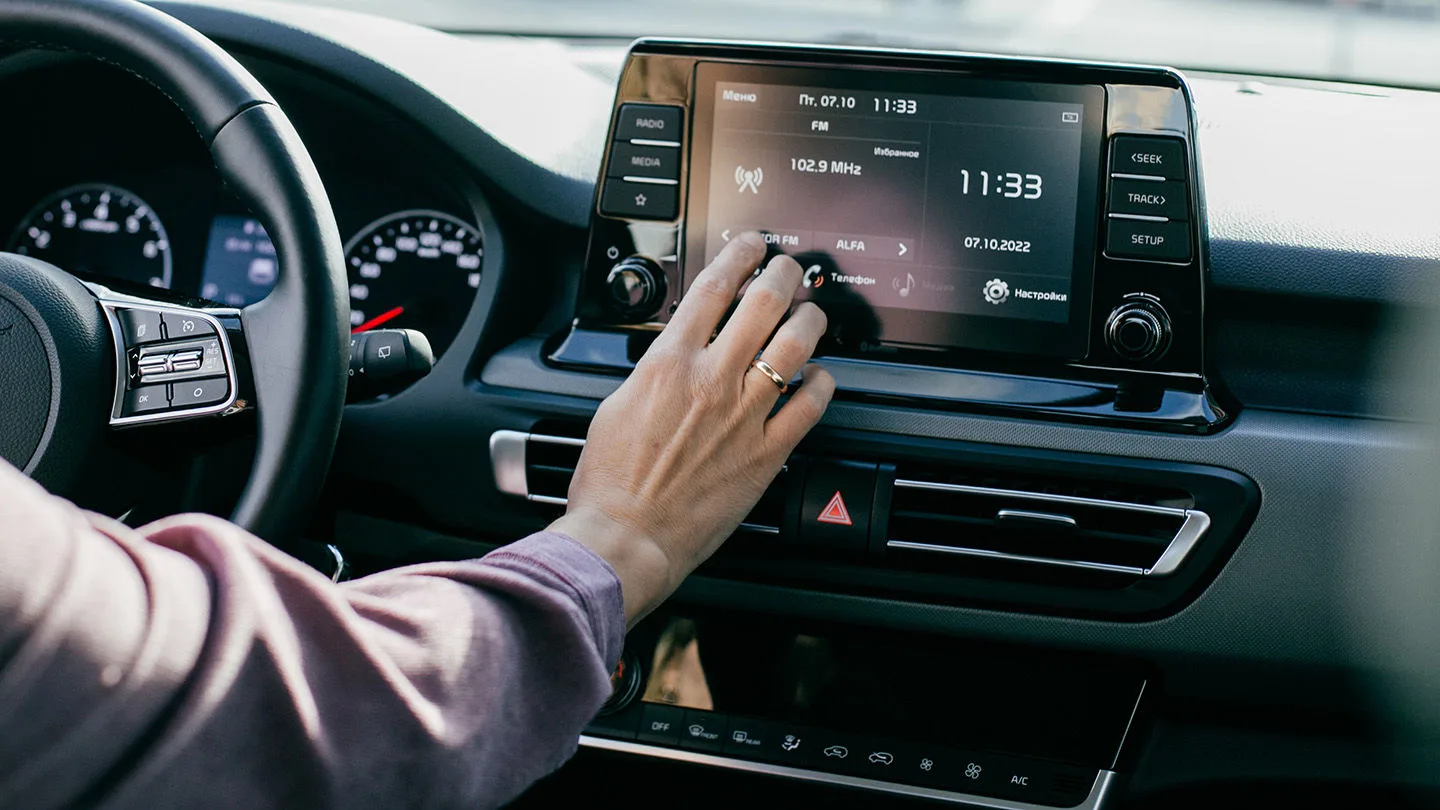 Frau schaltet Autoradio ein