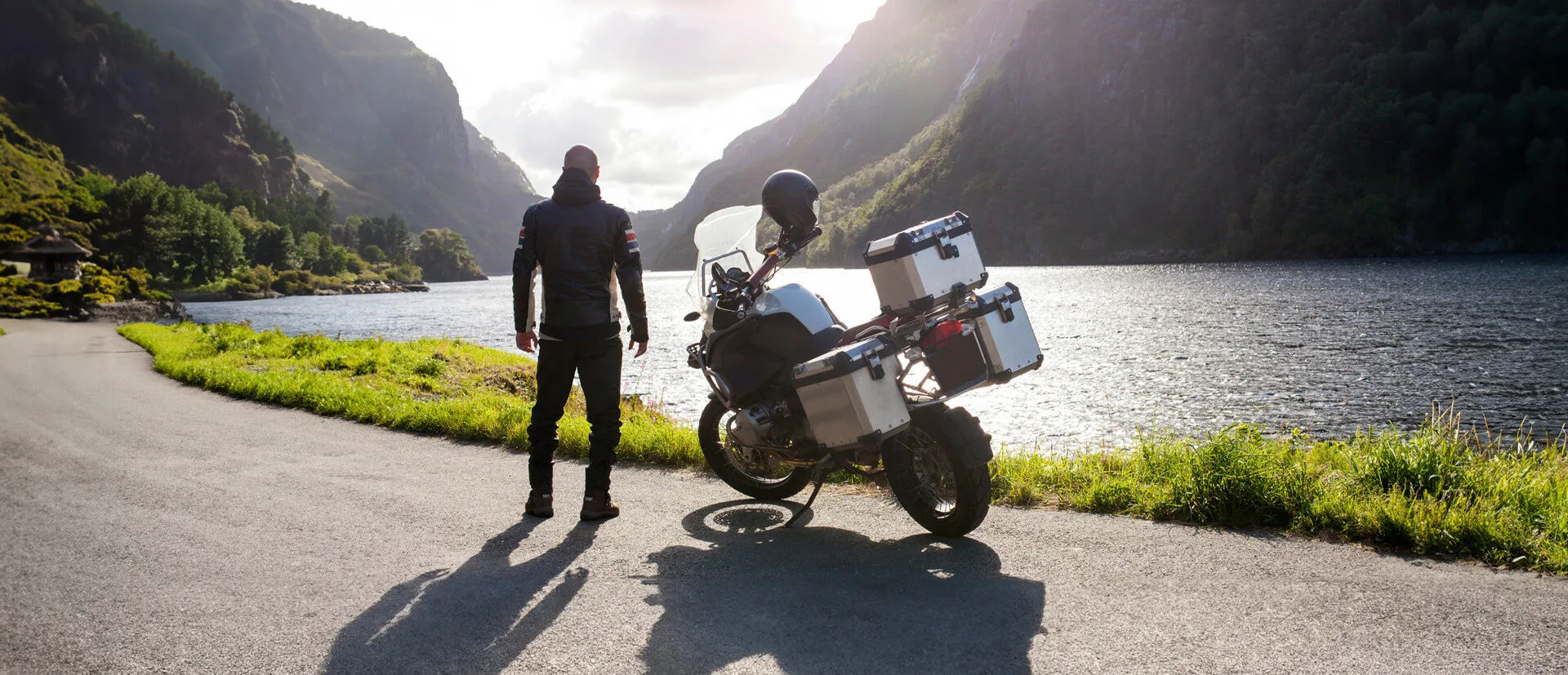 Mann neben einem Motorrad an einem See