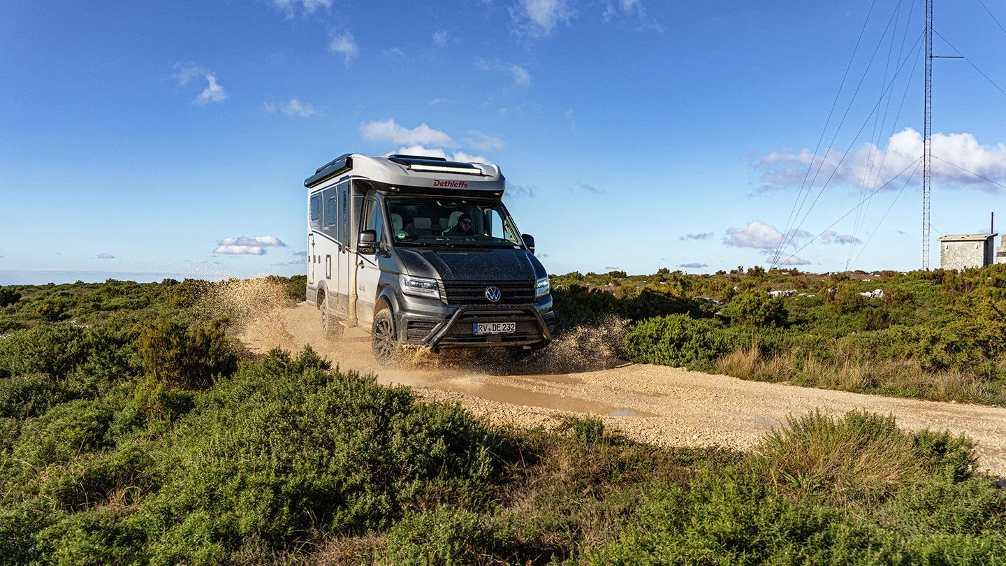 Allrad-Wohnmobil fährt auf einem Strand 