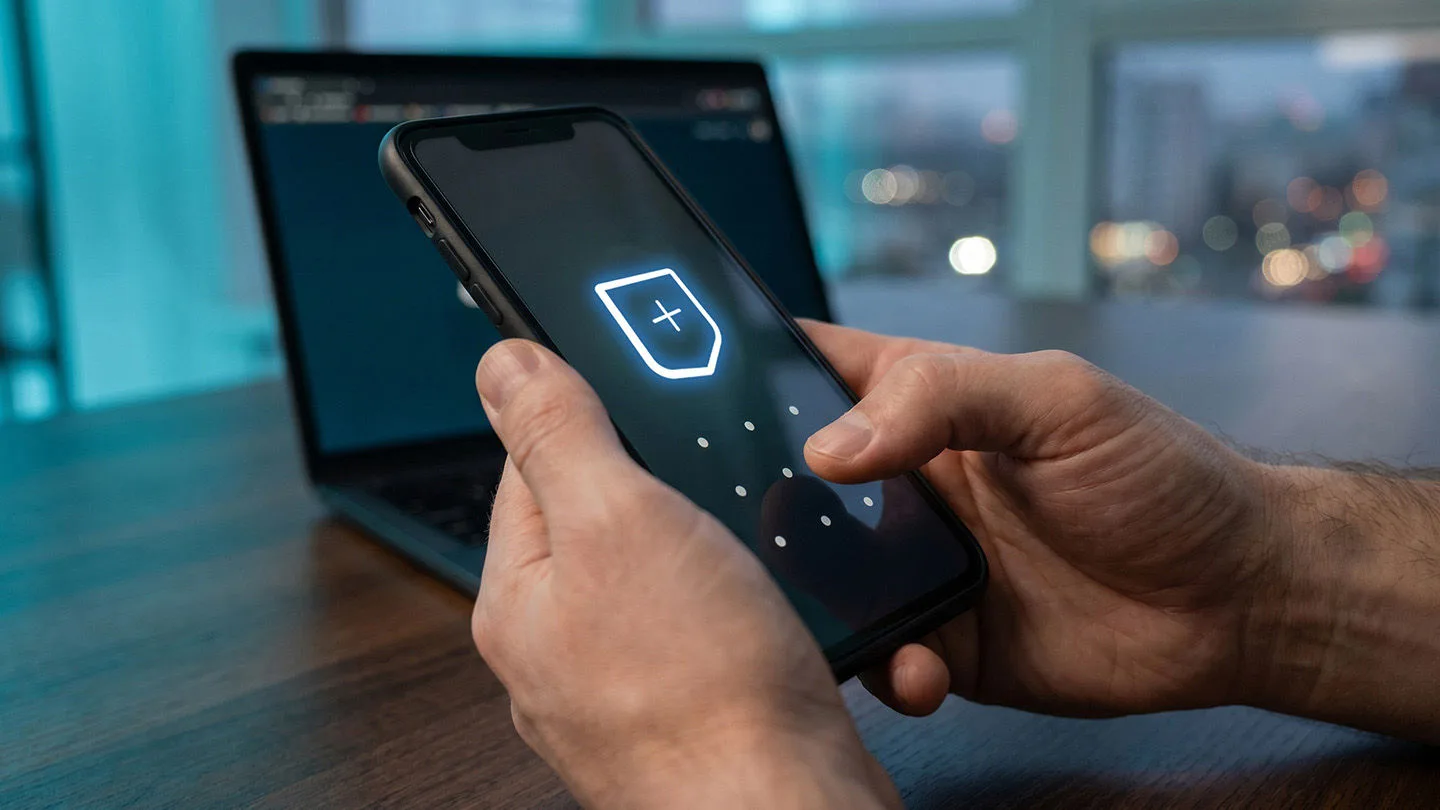 Ein Mann hält ein Smartphone in der Hand, über dem ein Vorhängeschloss schwebt, sinnbildlich für Sicherheit im Internet.