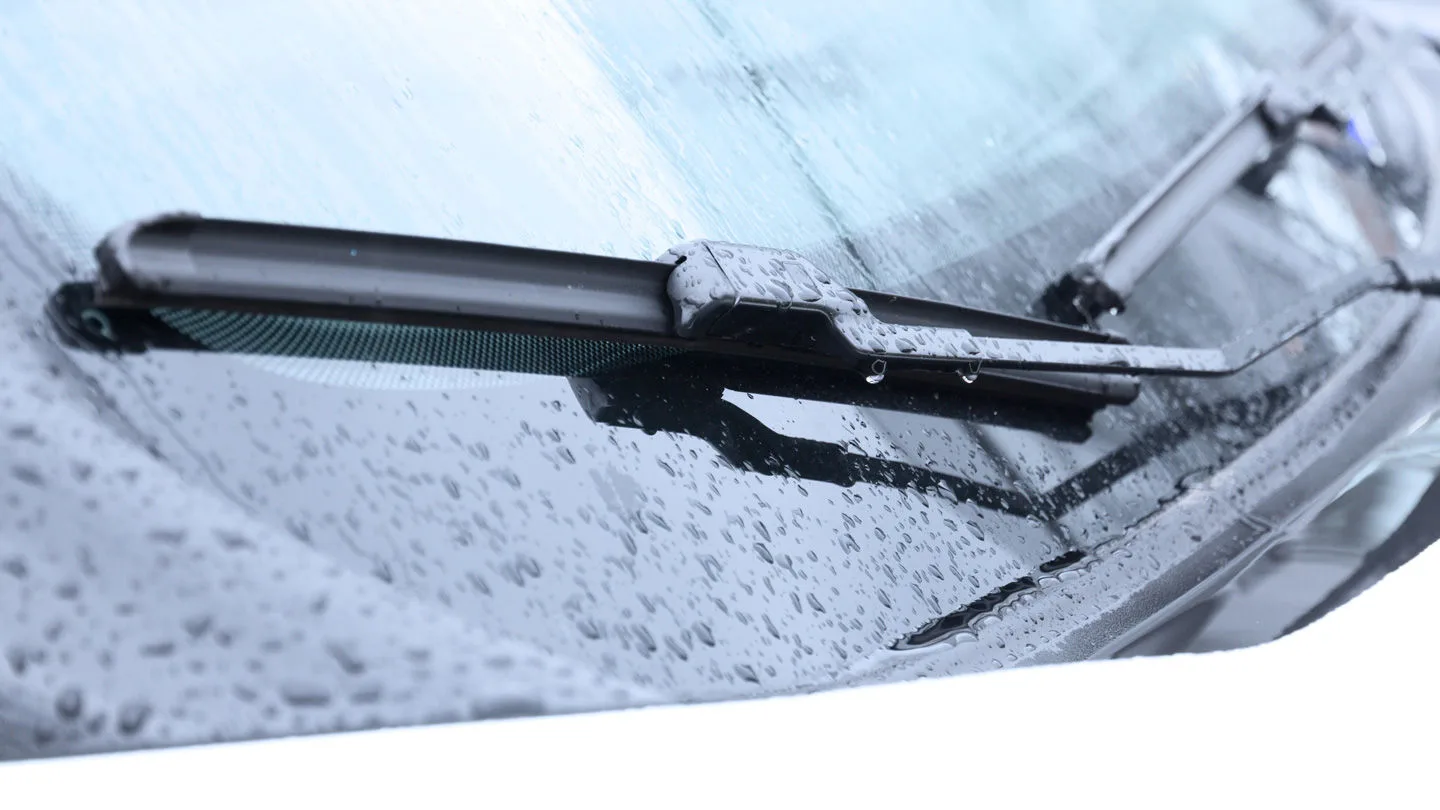 Scheibenwischer an der Frontscheibe eines Autos, mit Regentropfen benetzt