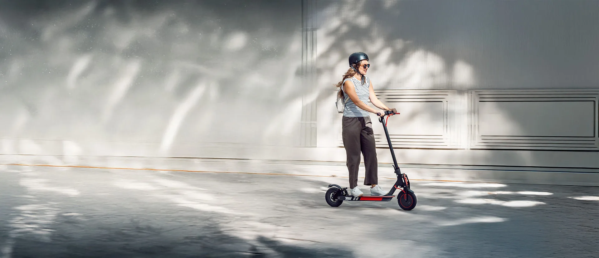 Wer haftet bei E-Scooter Unfällen? Eine Frau fährt auf einem E-Scooter